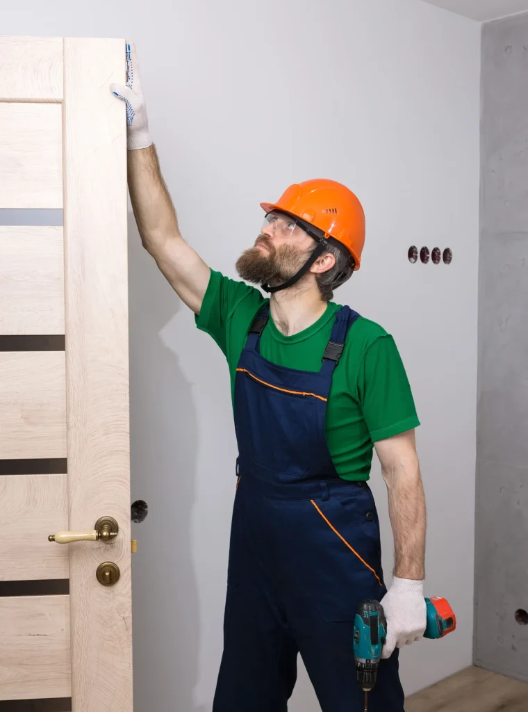 un-serrurier-masculin-installe-une-porte-dans-un-appartement-le-type-travaille-avec-un-tournevis (1) (1)