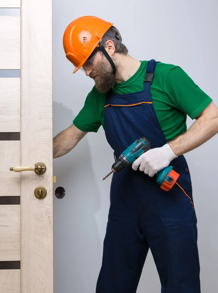 un-serrurier-masculin-installe-une-porte-dans-un-appartement-le-type-travaille-avec-un-tournevis-_1_